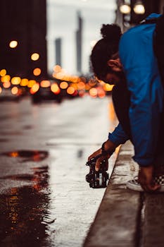 黄昏时分，一个人在潮湿的城市街道上拍照，灯光模糊