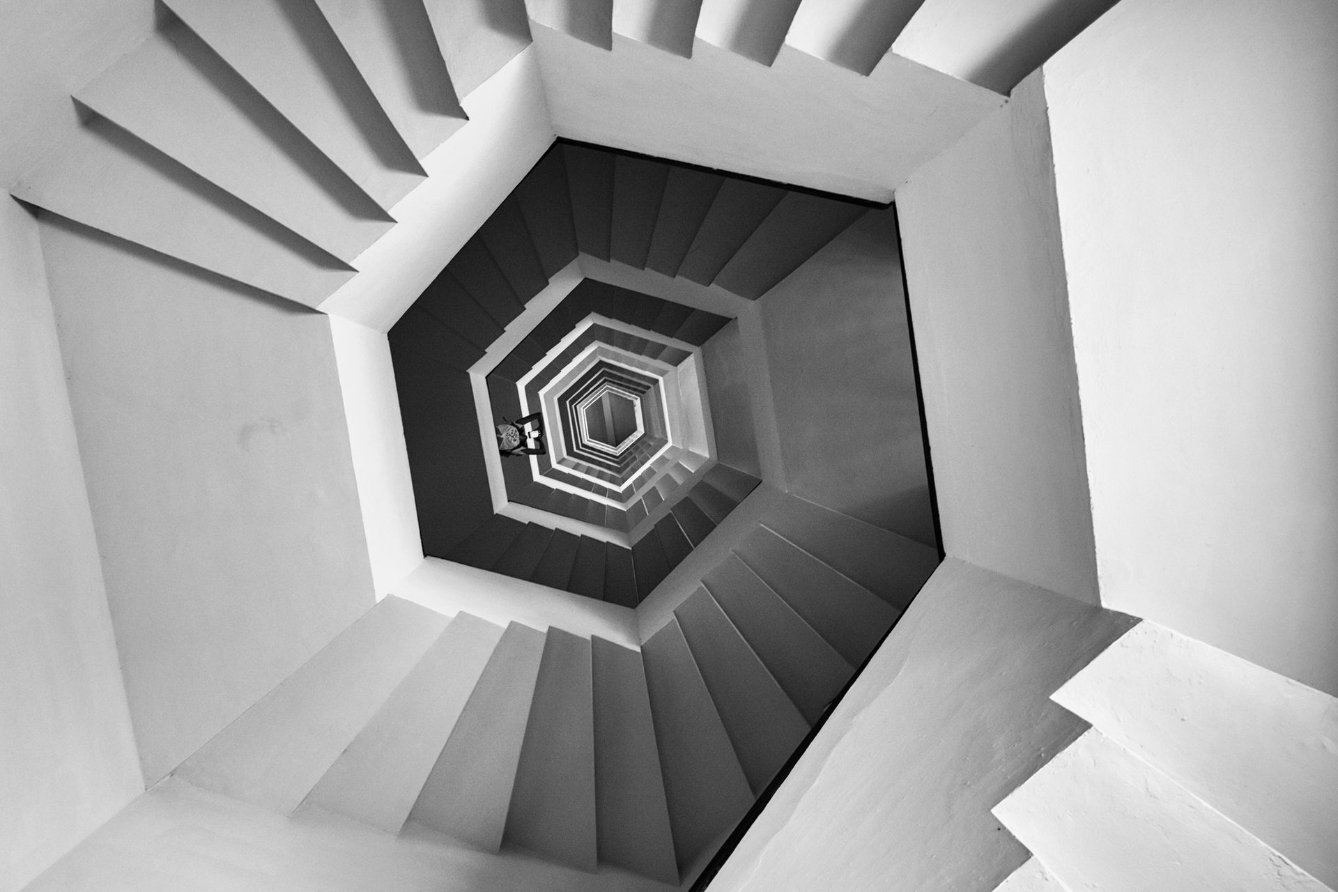 Artistic black and white photo of a geometric staircase from a unique architectural perspective.