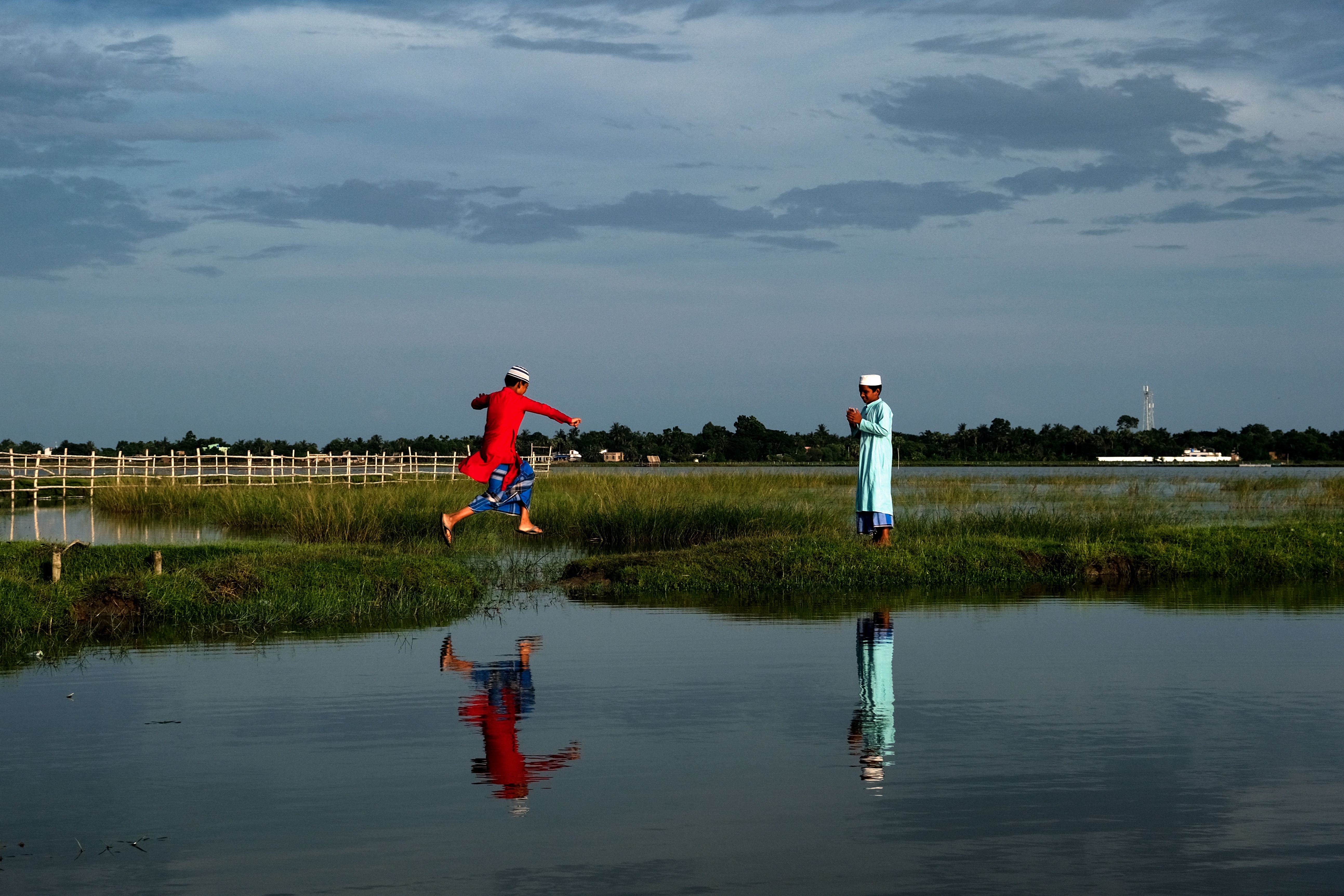 Two children enjoy a vibrant summer day by the lake, reflecting joy and leisure.