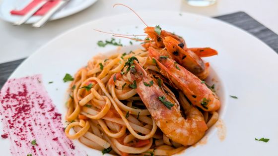 Linguine in light tomato sauce topped with whole red prawns and chopped parsley