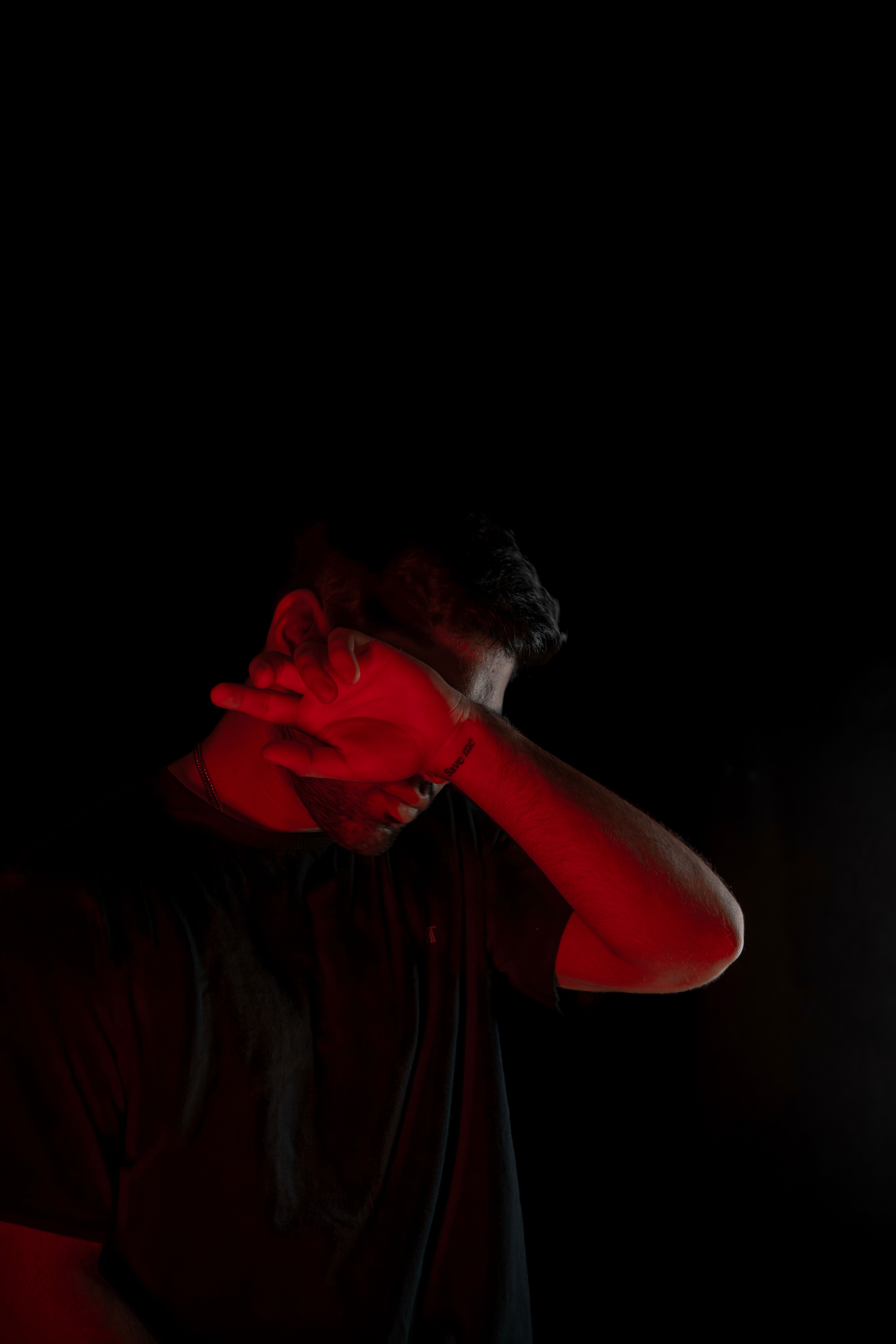 A man with his hands covering his face in the dark · Free Stock Photo