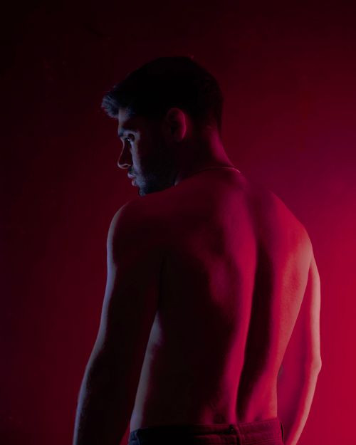 Free Silhouette of a shirtless man in low light with red backlighting. Stock Photo