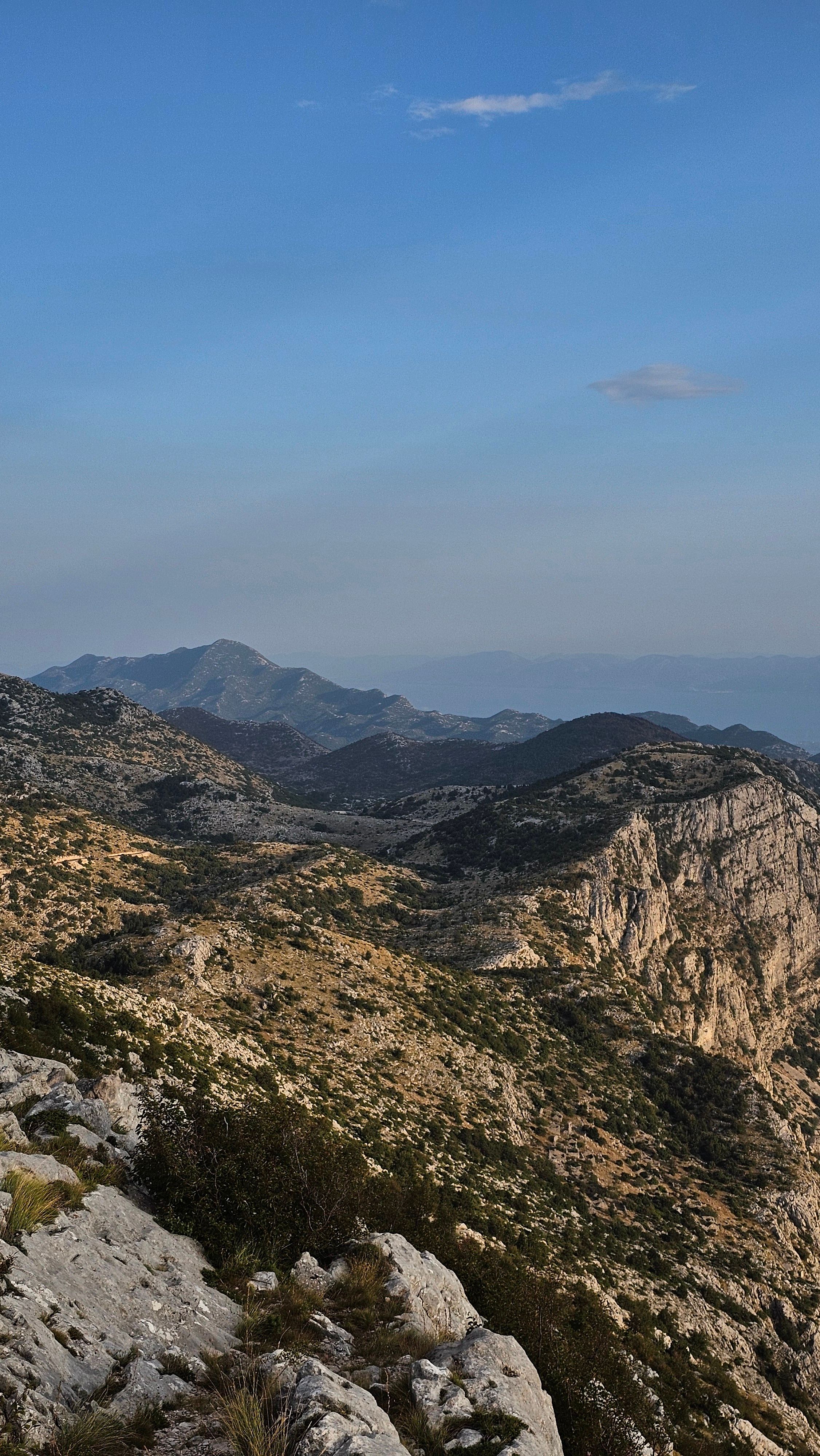 Scenic view of rugged mountain range under clear summer sky, ideal for travel inspiration.