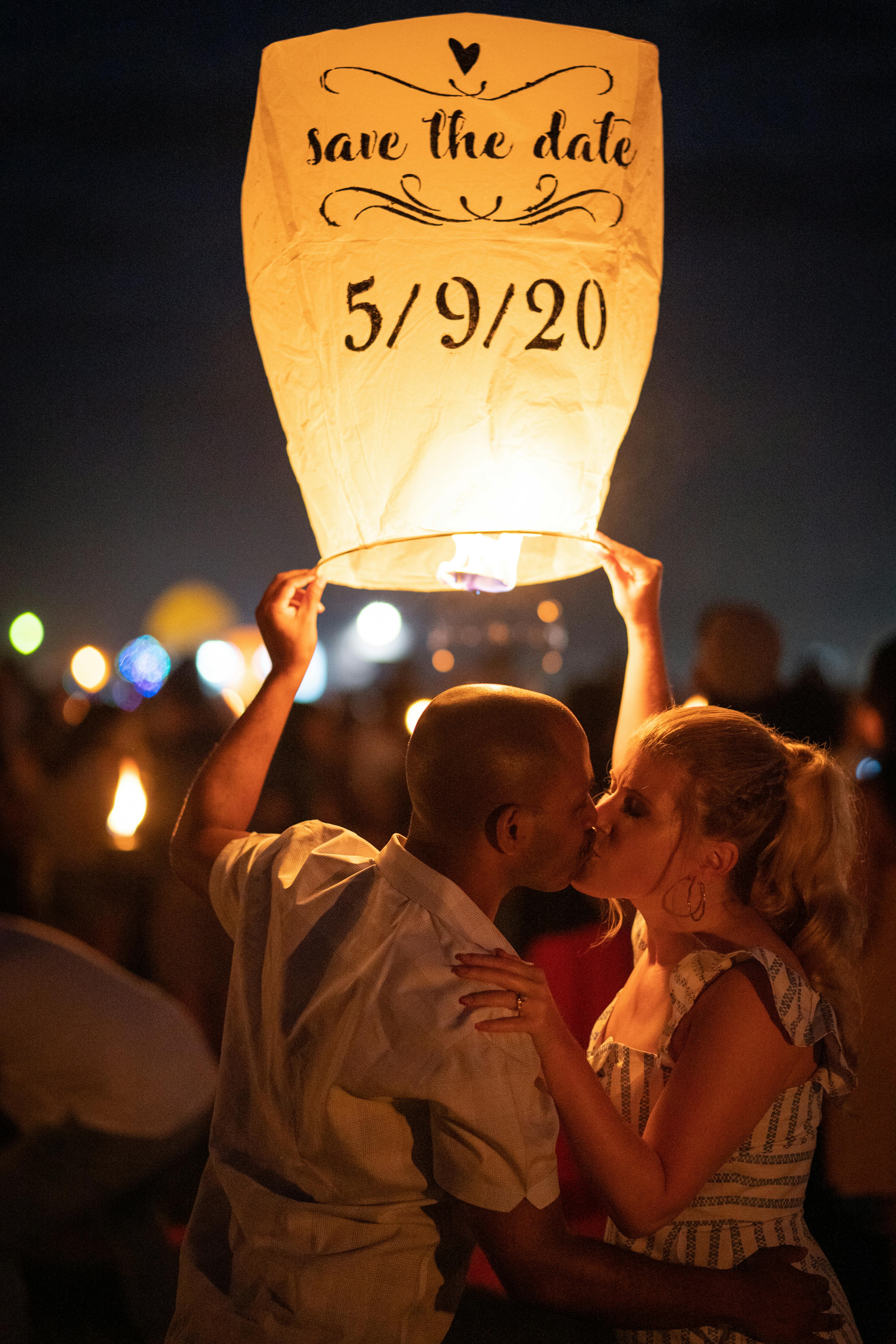 一对夫妇在夜间聚会的发光灯笼下浪漫接吻