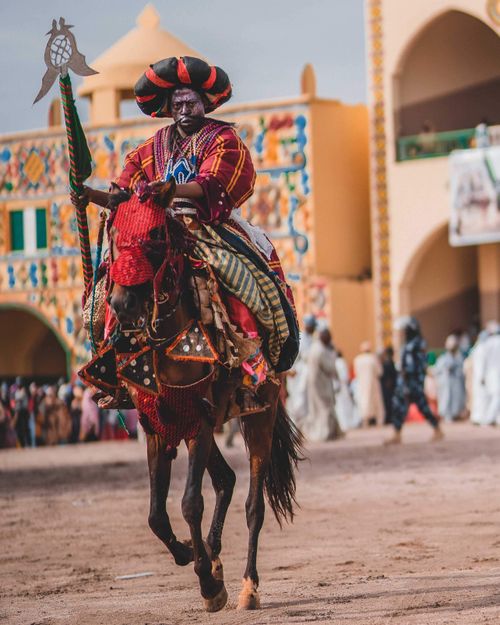Free A vibrant horseman in traditional Nigerian attire participates in a festive parade in Zaria, Nigeria. Stock Photo