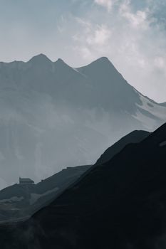 Misty mountain landscape with silhouette and dramatic fog, capturing nature's serene beauty.