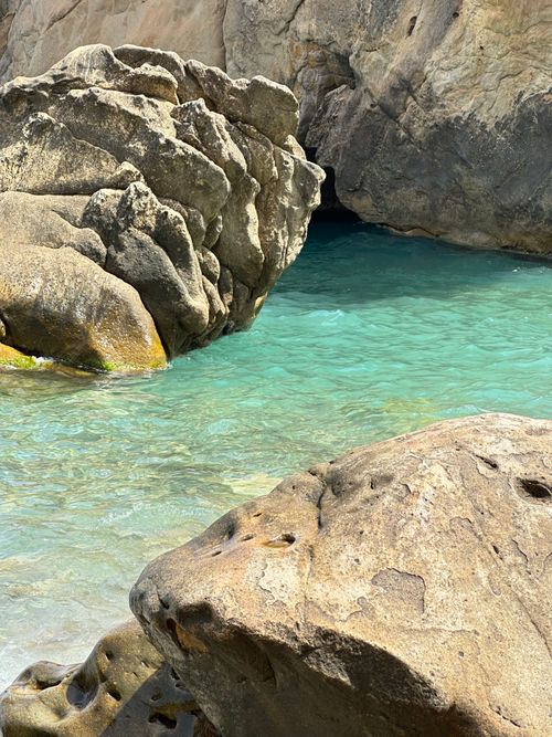 Free Discover tranquility with rocky formations and crystal-clear blue waters by the beach. Stock Photo