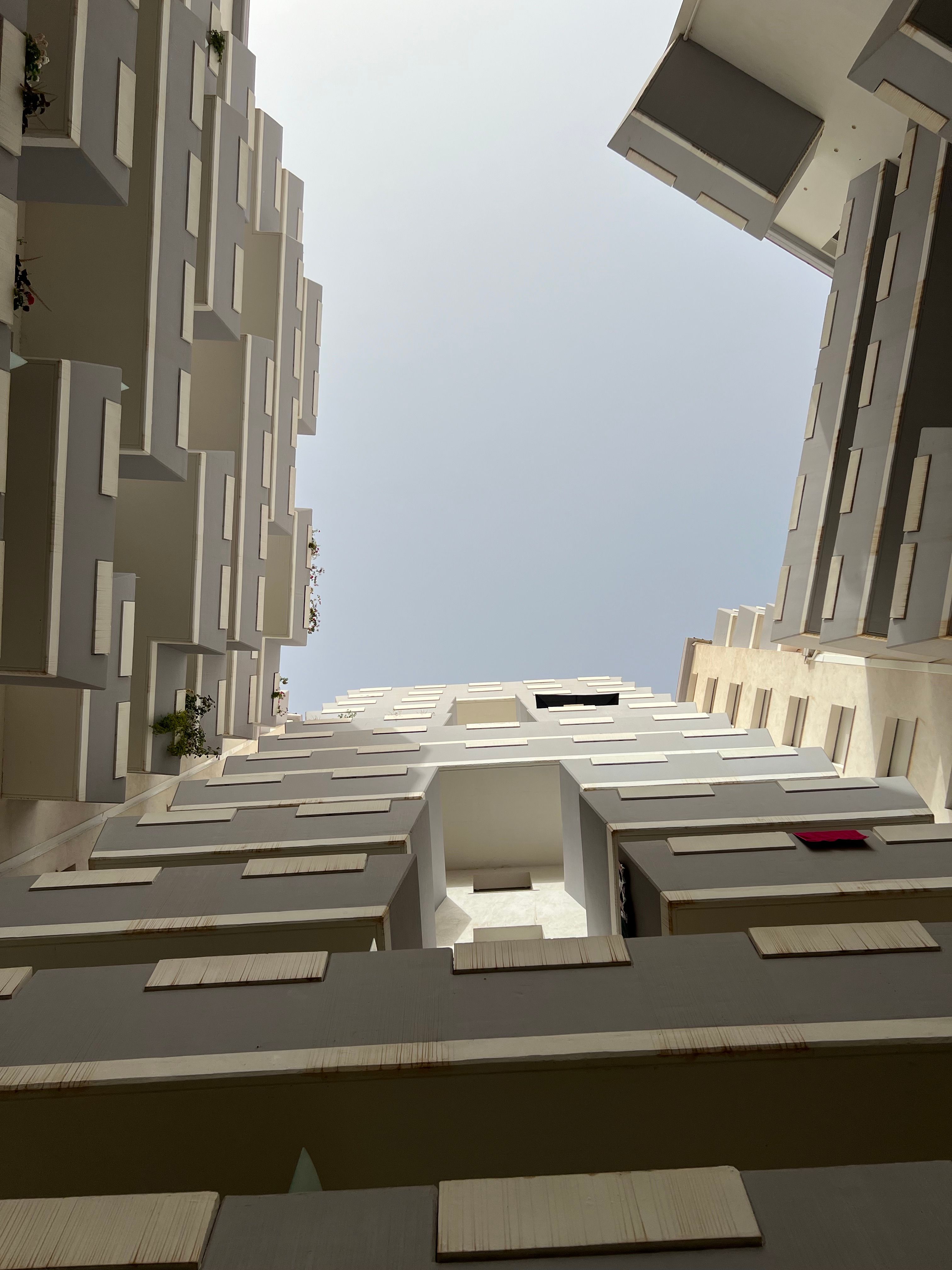 Modern apartment buildings with unique architectural design, viewed from below.