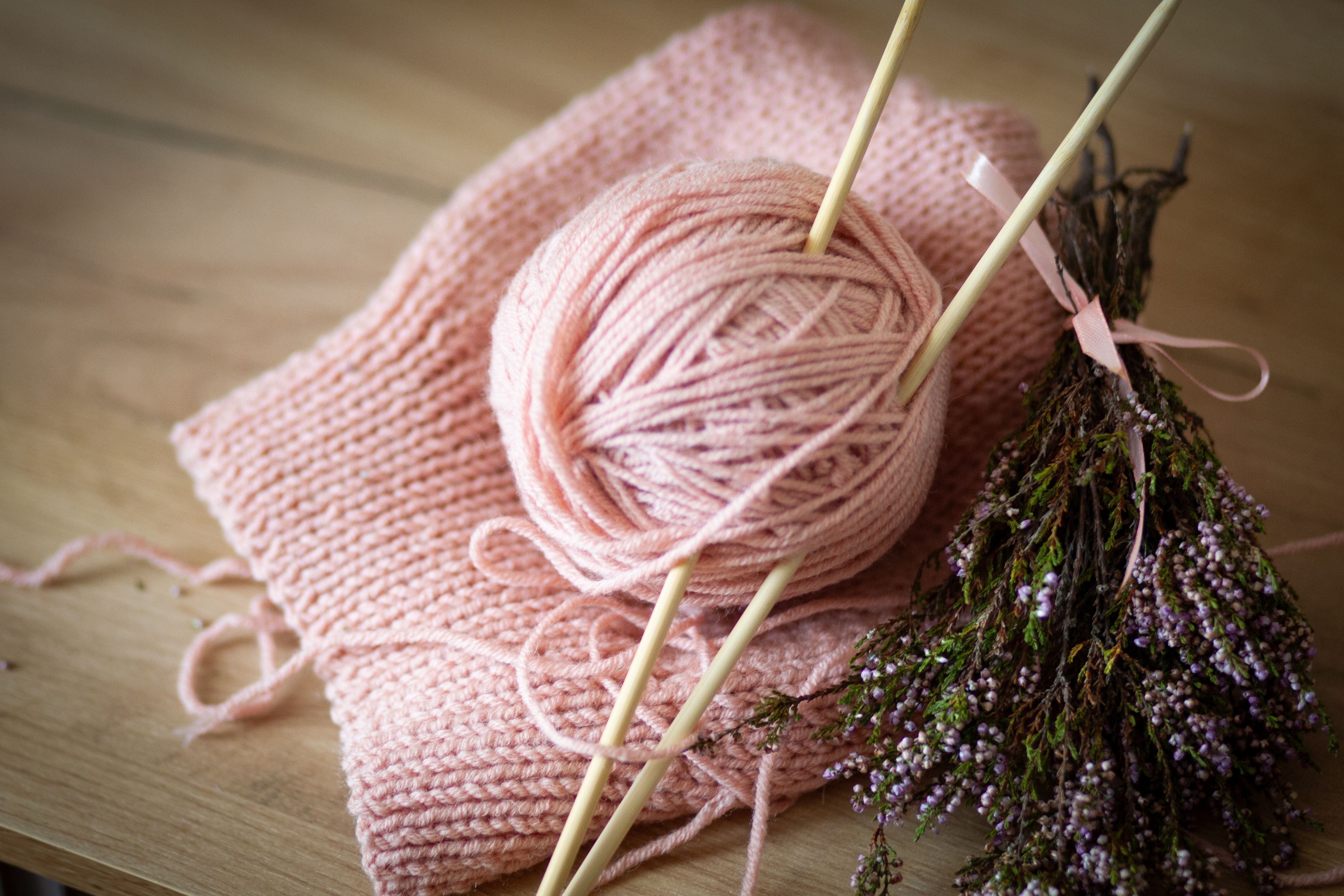 A pink ball of yarn and knitting needles · Free Stock Photo