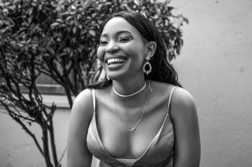 Free Elegant and joyful black and white portrait of a young woman laughing outside. Stock Photo