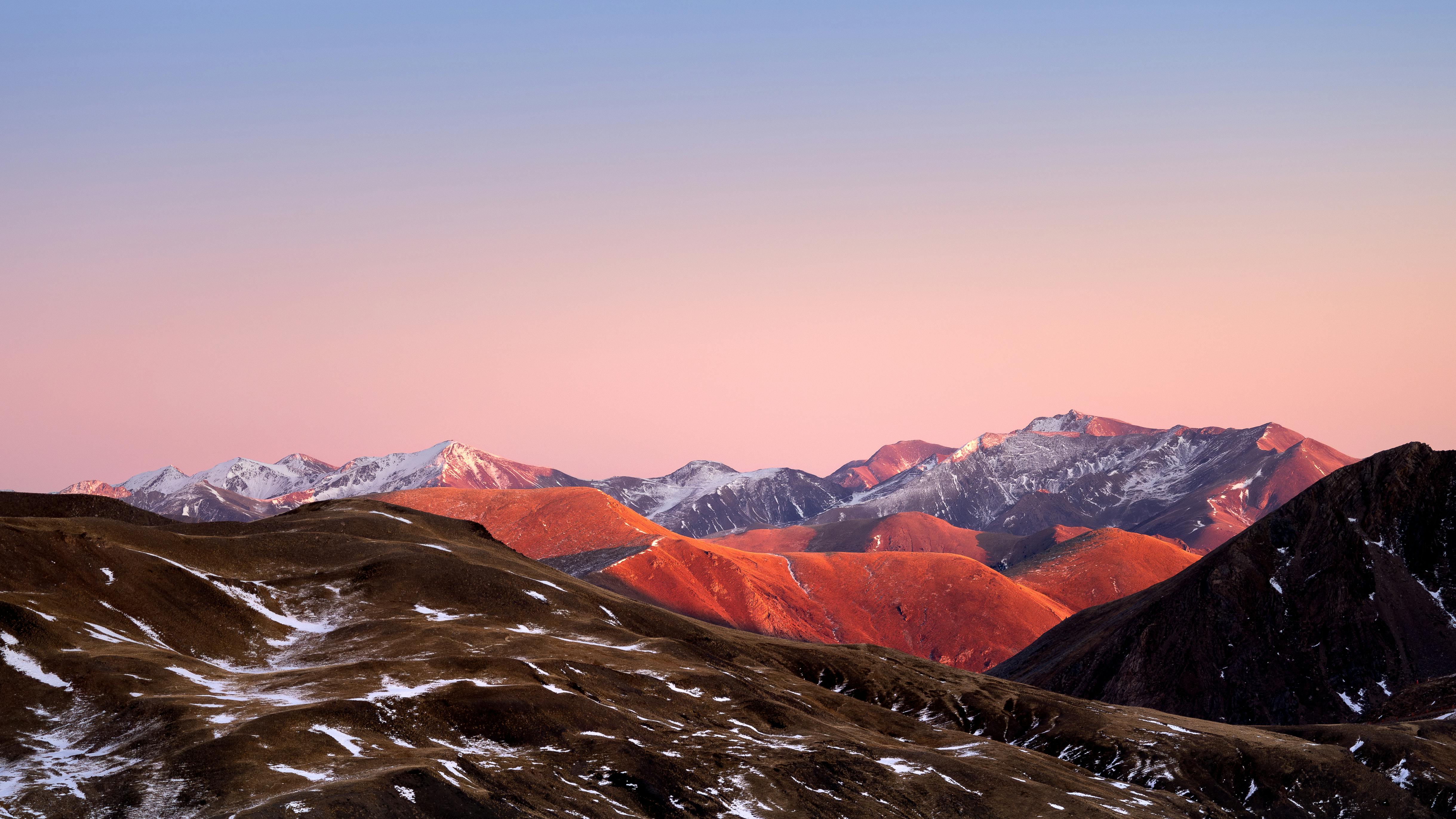Stunning sunset view of the Pyrenees mountains with snow-capped peaks and vibrant colors.
