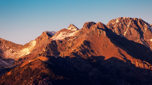 Majestic Pyrenees mountain peaks illuminated by sunset light, showcasing natural beauty.