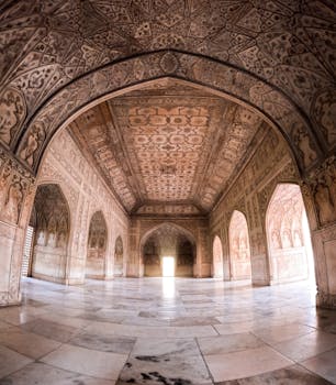 Explore the intricately designed Mughal-era interior space with arches and detailed ceilings in Agra, India.