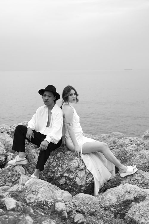 Free Stylish couple posing on rocky beach in monochrome elegance. Stock Photo