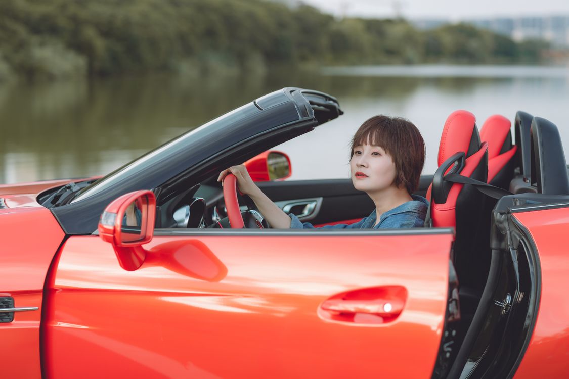 A woman sitting in a red sports car · Free Stock Photo