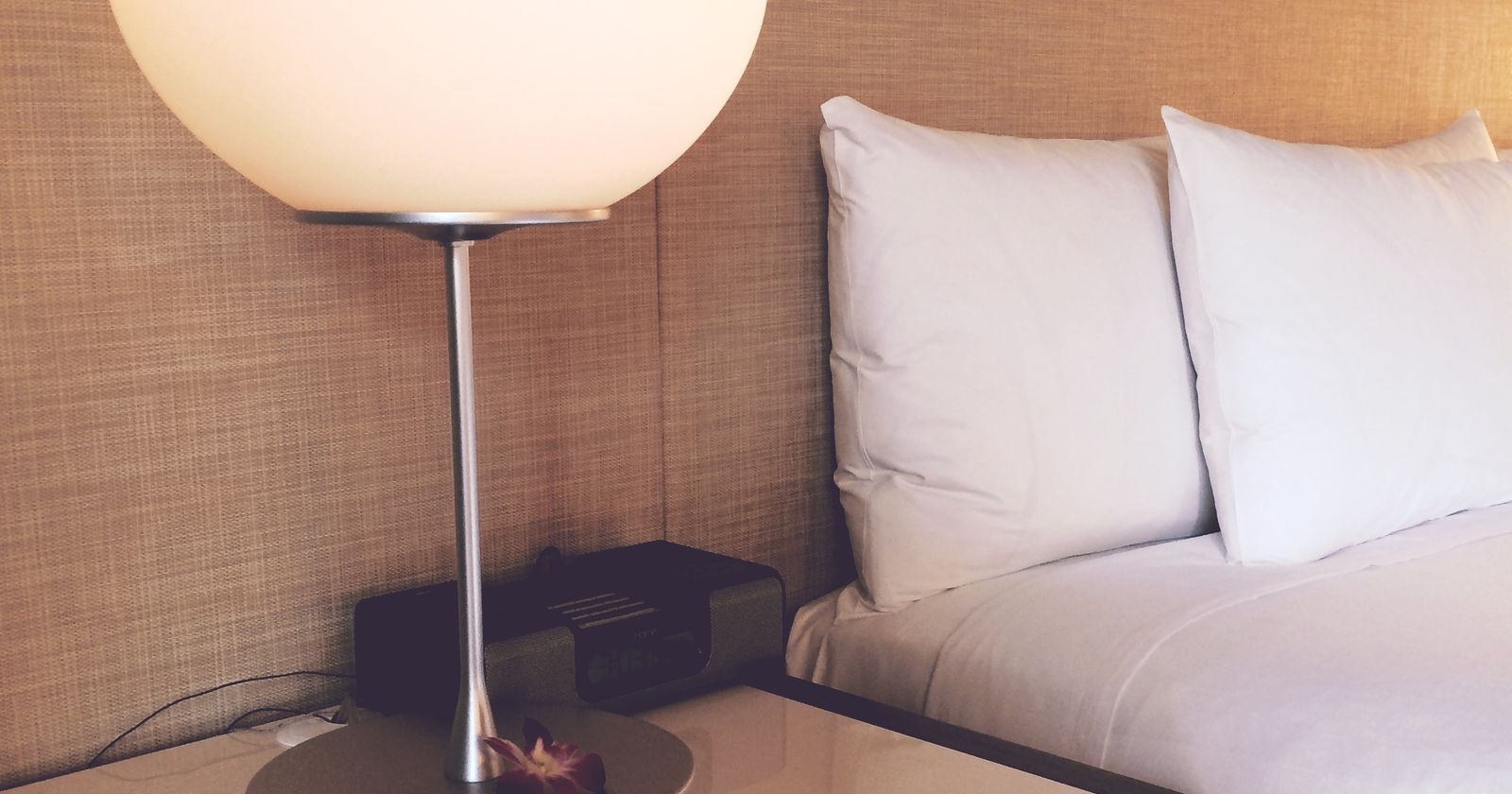 Modern hotel room with a made bed and large window