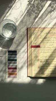 A serene indoor scene with shadows, a book, and a glass of water, creating a vintage ambiance.