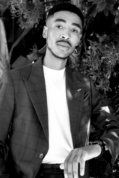 Free Stylish young man in a suit posing outdoors in a black and white portrait. Stock Photo