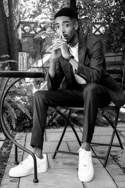 Free Stylish man in a suit seated at a garden table, contemplating. Stock Photo