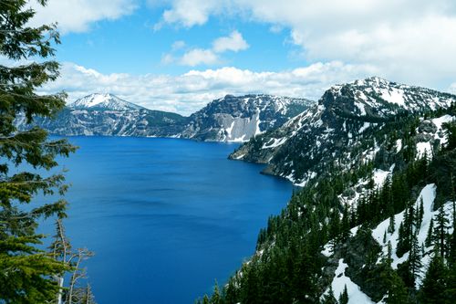 Free A breathtaking view of a snow-capped mountain range with azure blue lake, captured in winter. Stock Photo