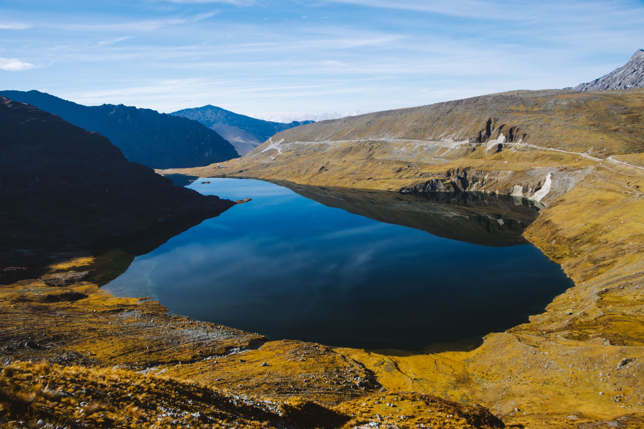 A tranquil mountain lake reflecting the sky in the Andes, perfect for travel and nature photography.