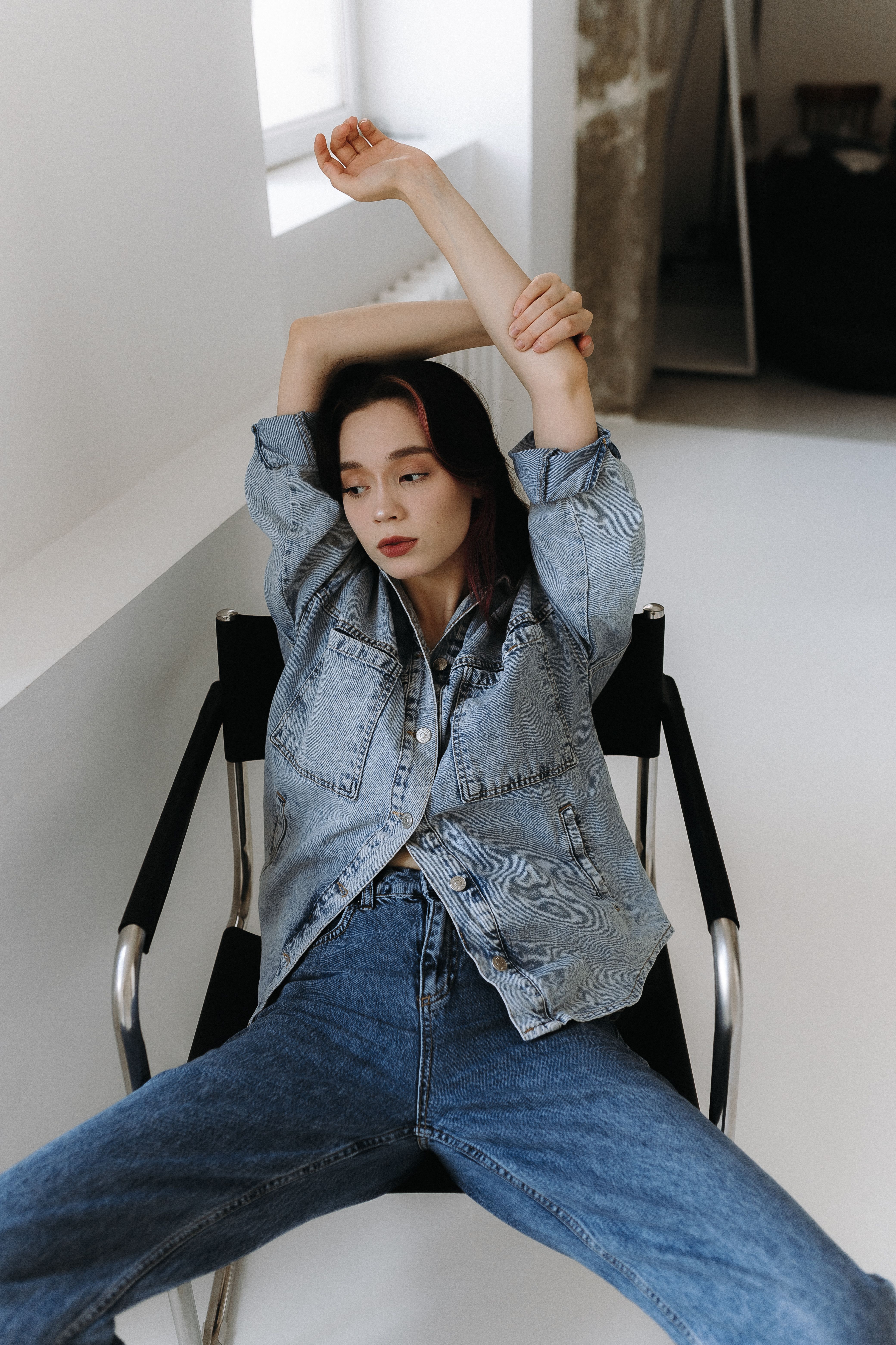 A woman sitting on a chair wearing jeans and a denim jacket · Free ...