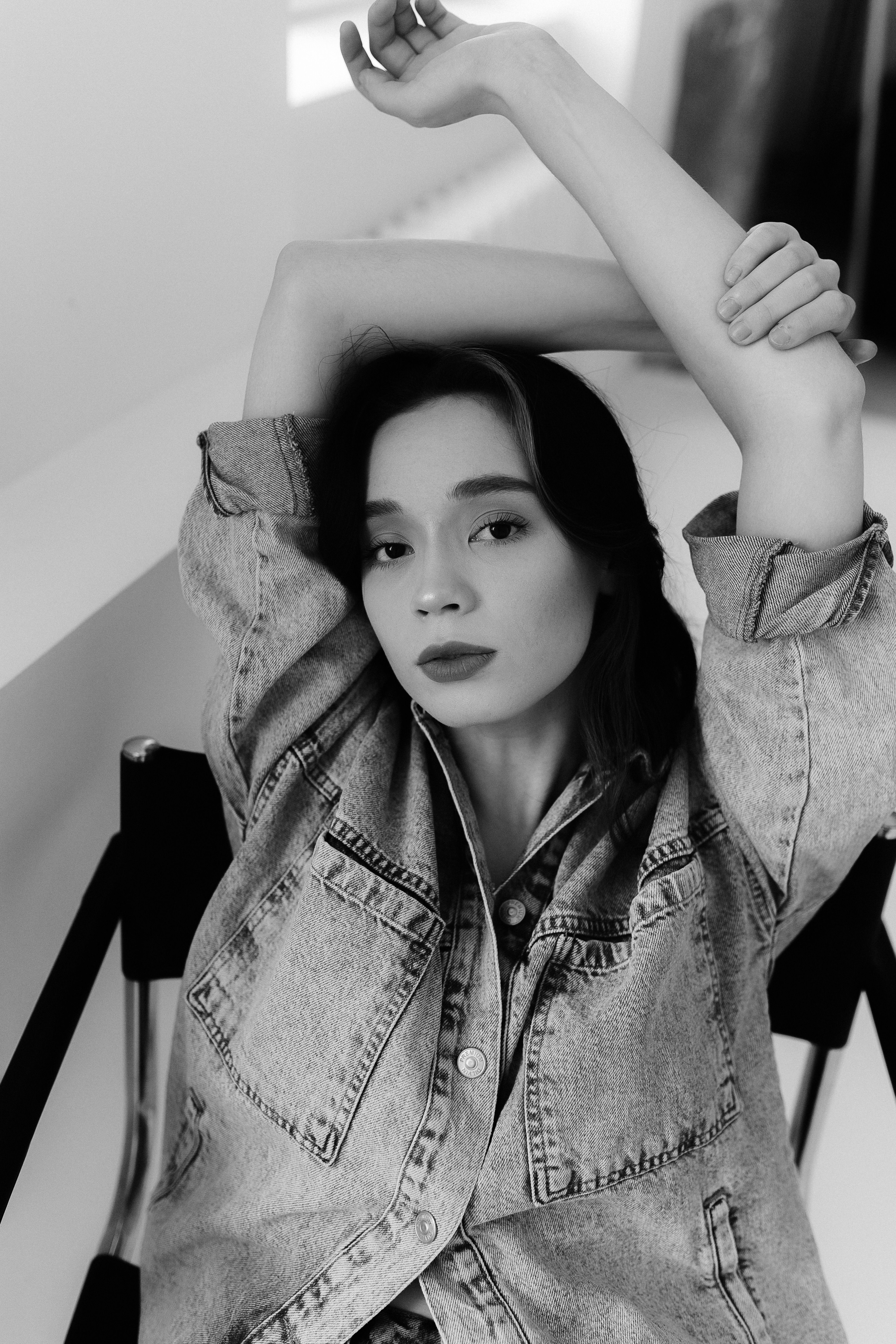 A woman in a denim jacket sitting on a chair · Free Stock Photo