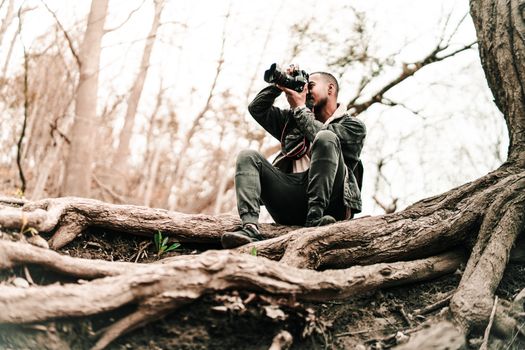 A man takes photos in a Toronto forest, showcasing nature and adventure.