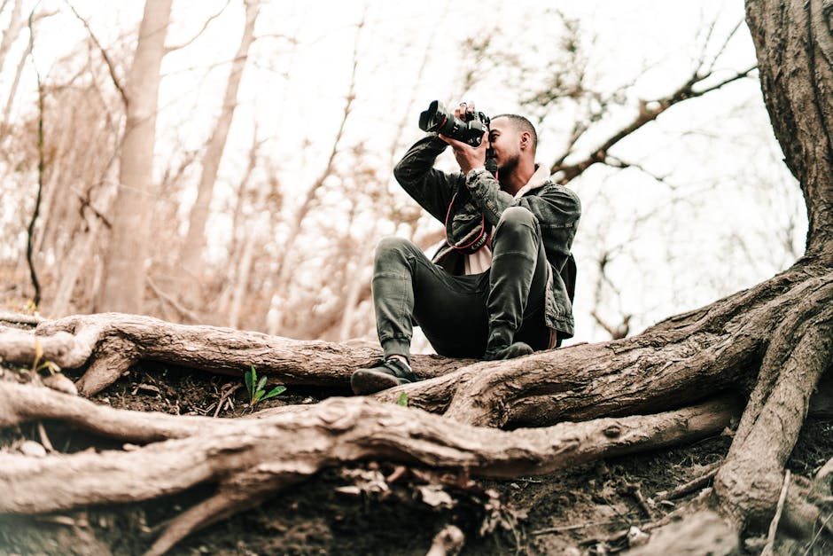 A man takes photos in a Toronto forest, showcasing nature and adventure.