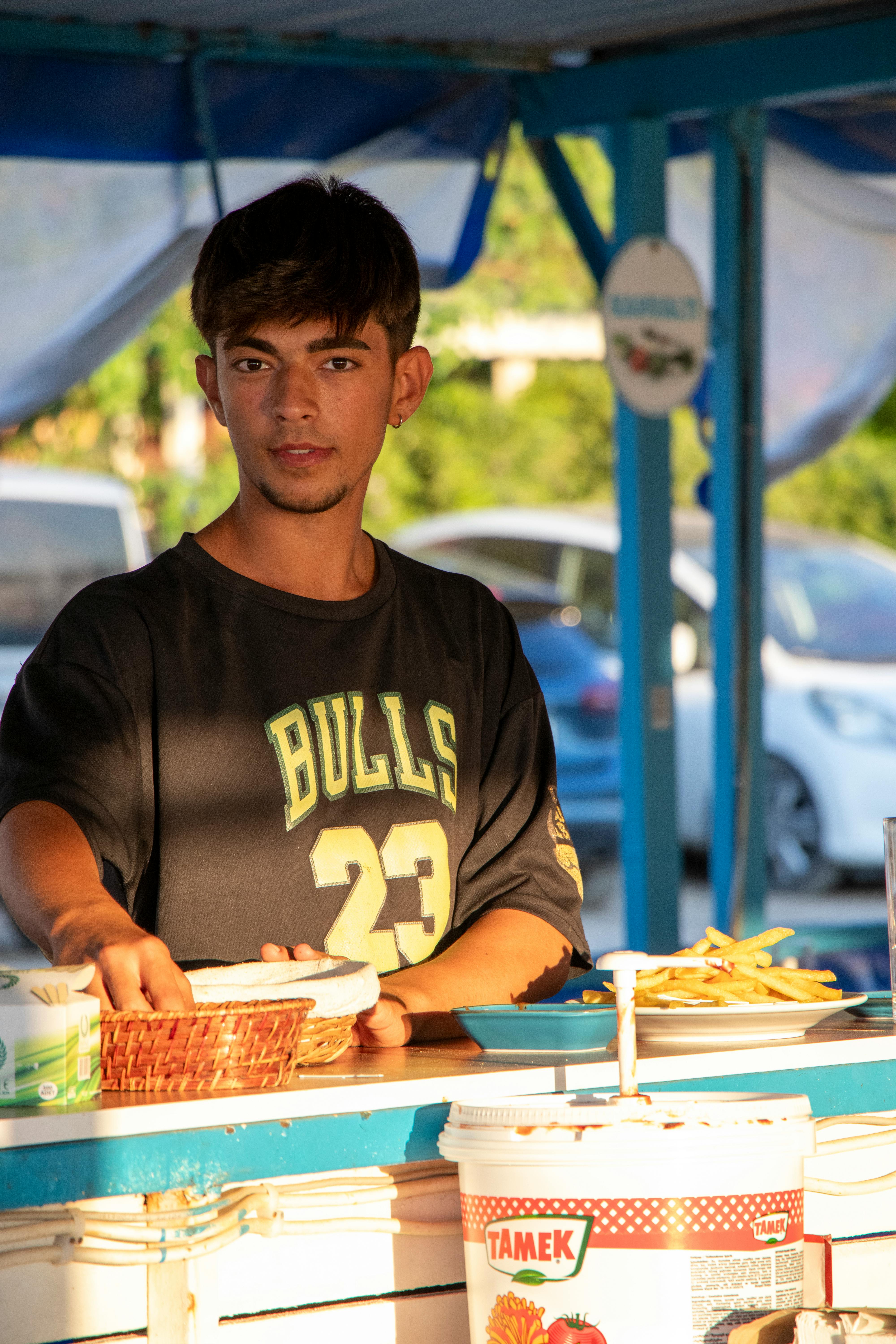 a man is serving food at a food stand