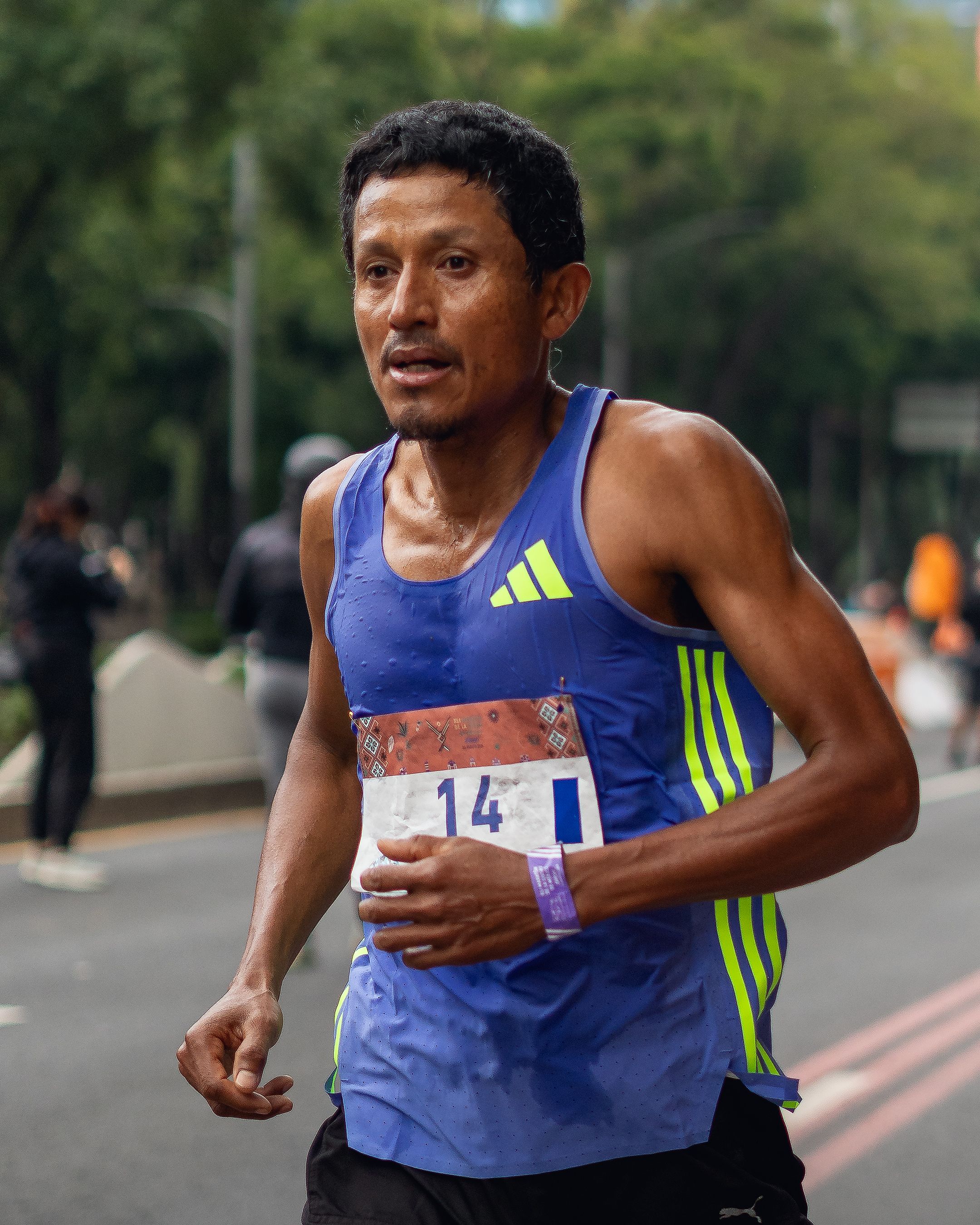 Focused athlete running a marathon on a street, exemplifying endurance and fitness.