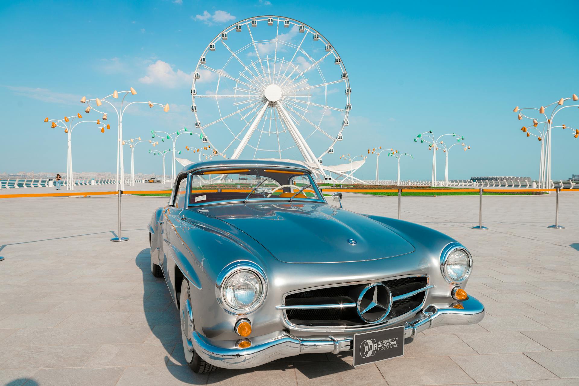 Vintage Mercedes-Benz in Baku, Azerbaijan with Ferris wheel background, ideal for luxury and travel themes.