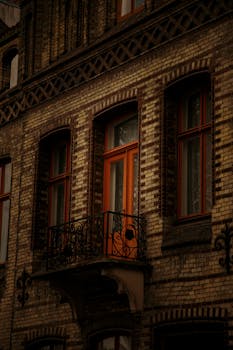 Explore the vintage charm of a historic brick facade with ornate balcony in Lübeck, Germany.