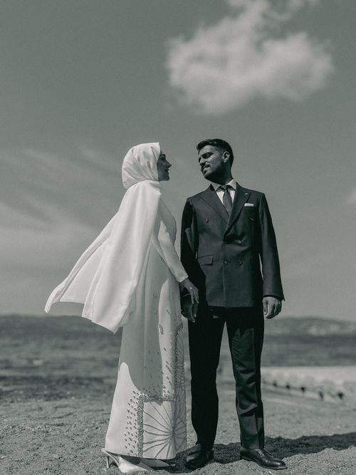 Free Black and white photo of a couple in wedding attire, outdoors by the beach. Stock Photo