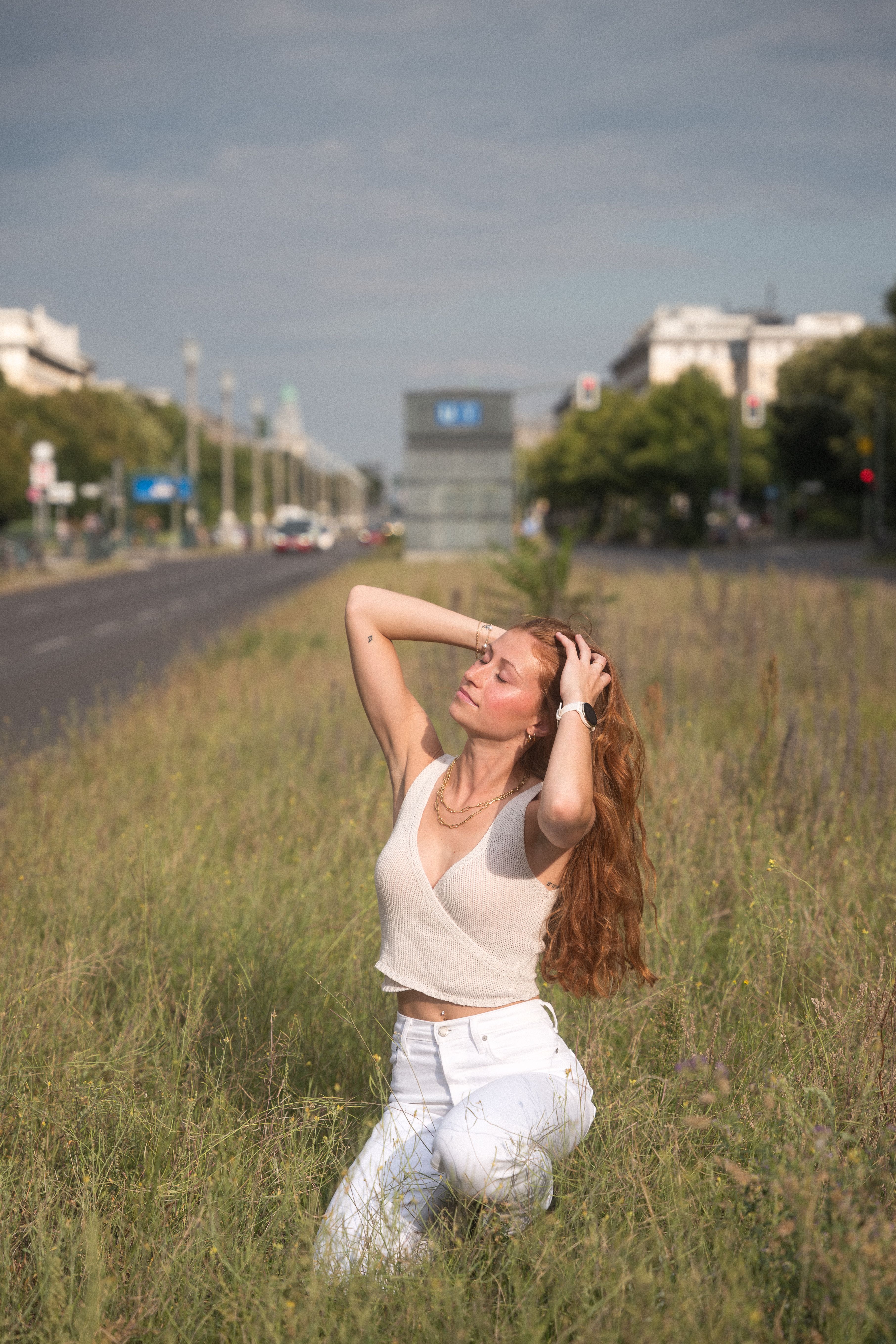 A woman in white pants sitting in the grass · Free Stock Photo
