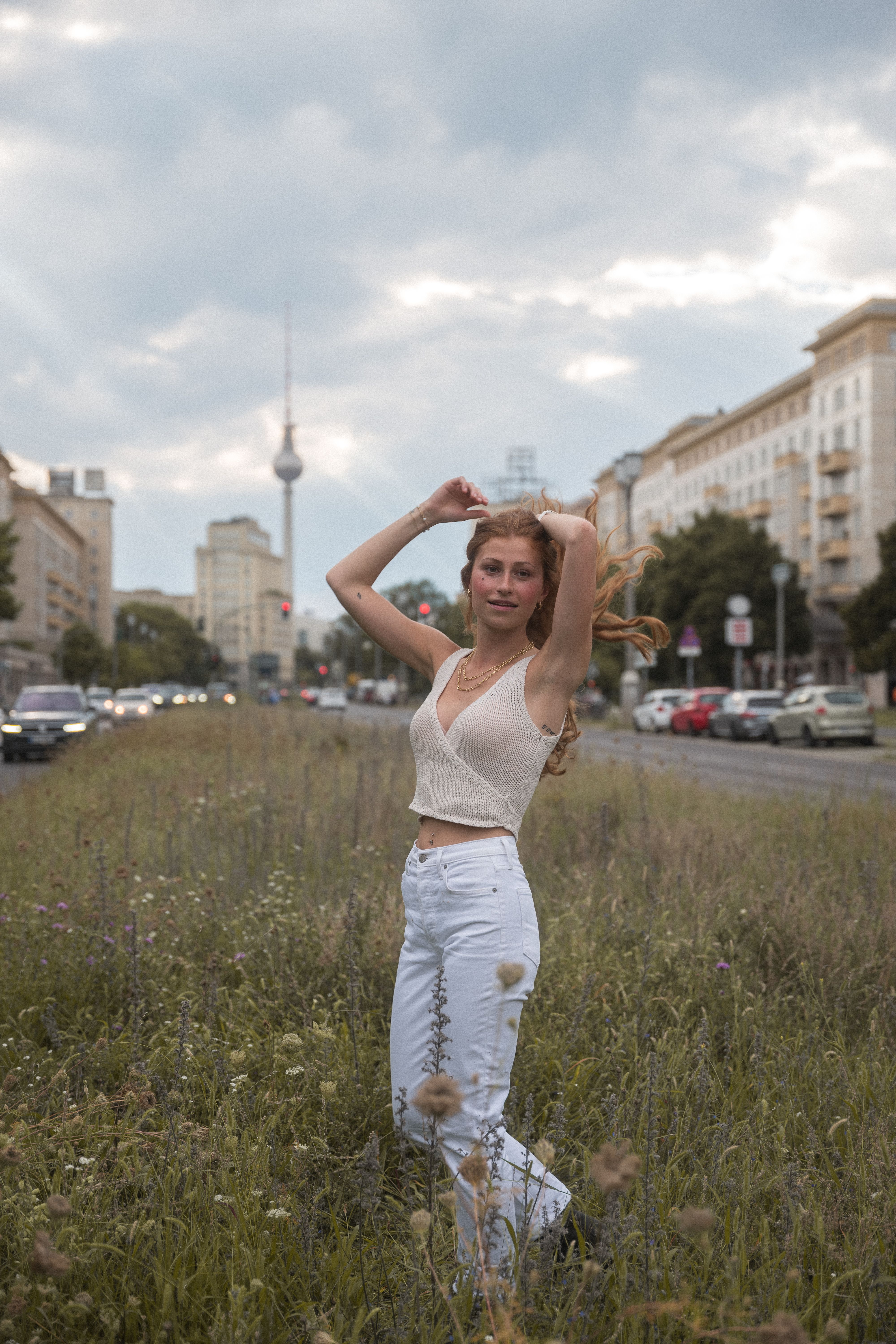 Woman enjoying a summer day amidst Berlin's iconic architecture and natural urban setting.