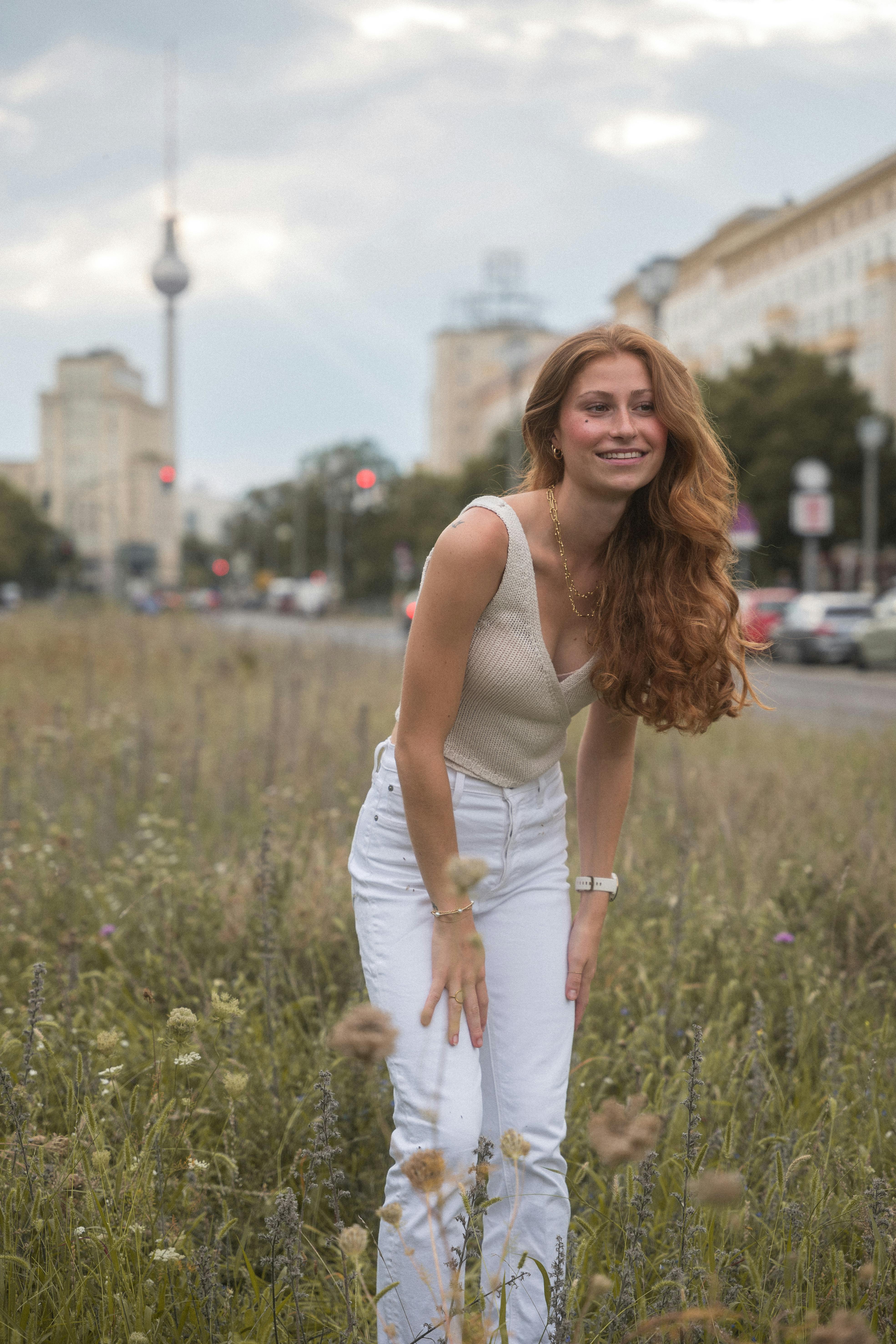 Young woman enjoying a summer day outdoors in Berlin, with the TV Tower in the skyline.