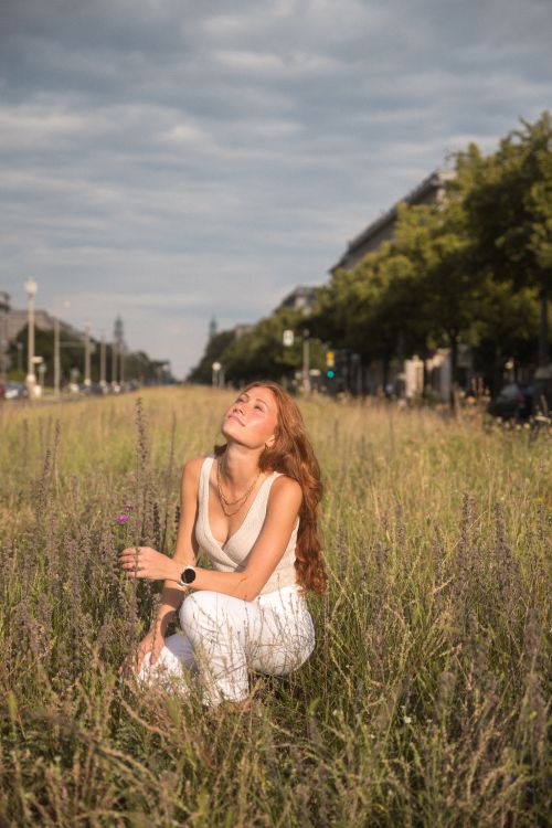 Free A carefree woman in a field enjoying the sunny day, exemplifying freedom and joy in Berlin, Germany. Stock Photo
