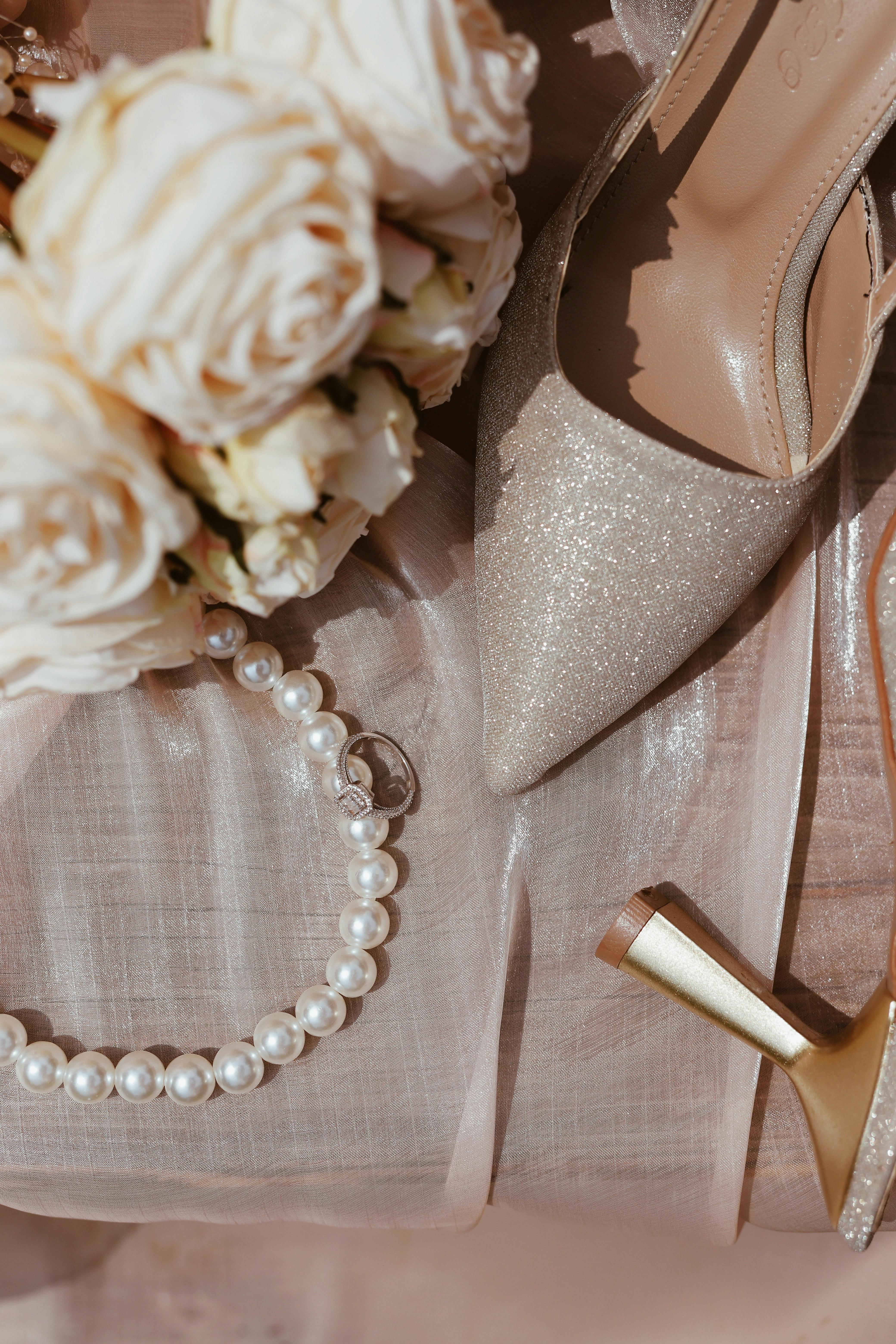 a wedding shoe and pearls on a table