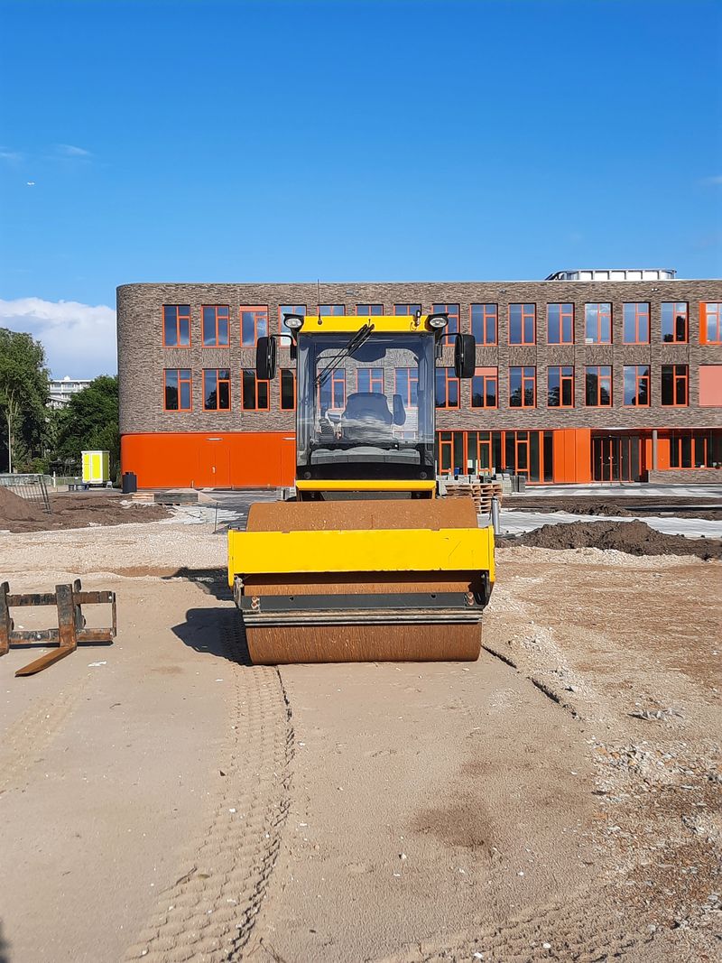 Rodillo tándem amarillo compactando una explanada