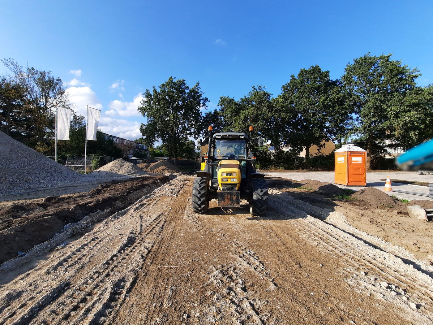 Tractor working on a dirt construction site under blue sky
