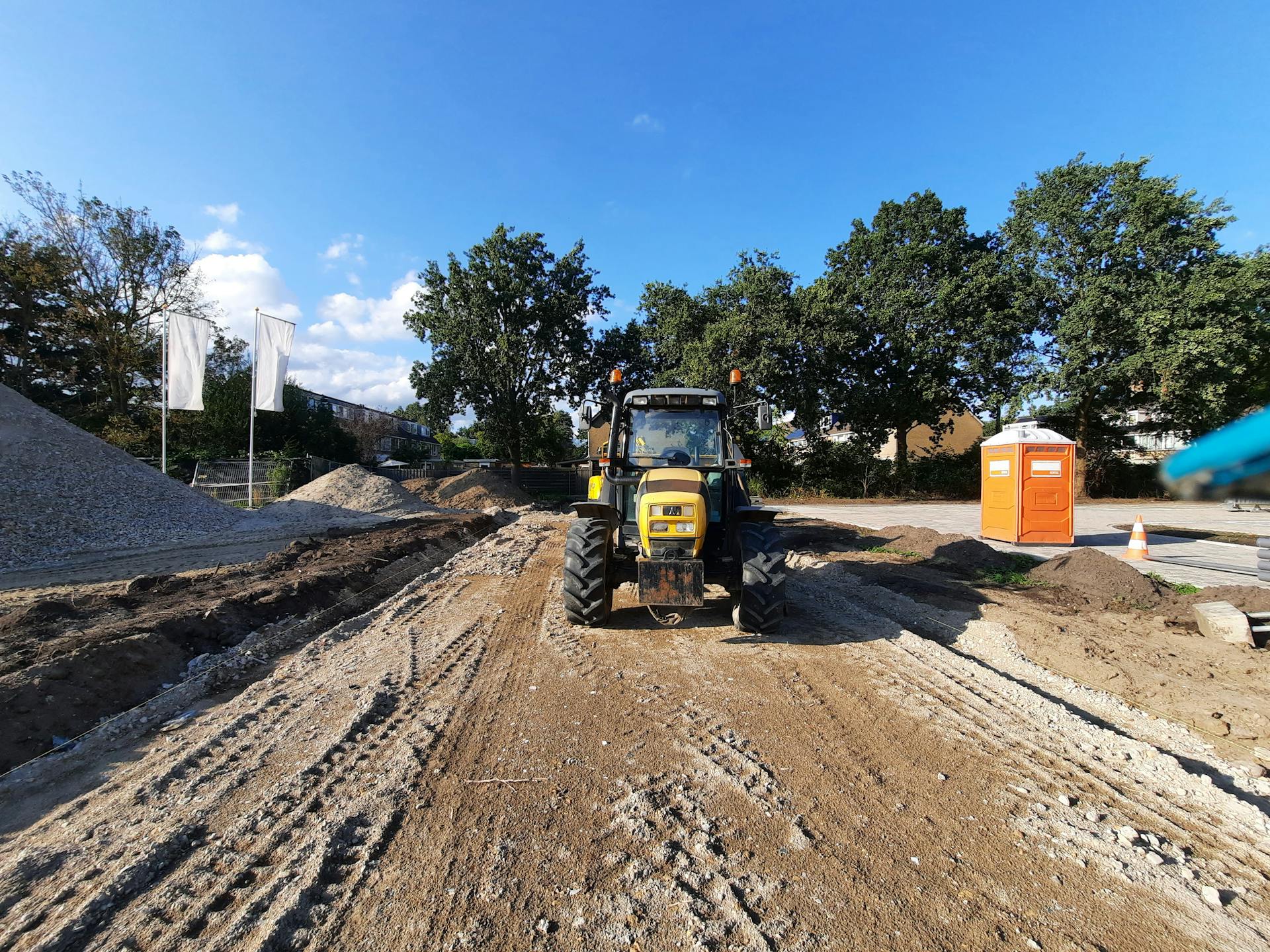 A tractor is driving on a dirt road