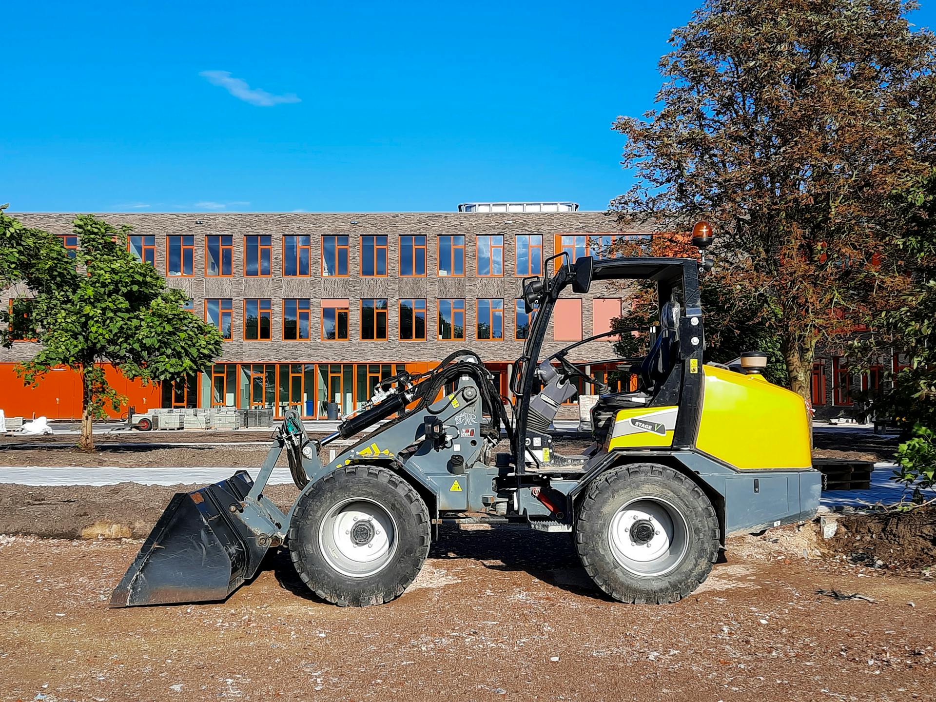 A small wheel loader parked in front of a building