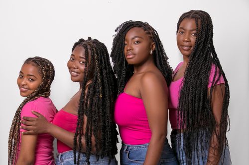 Free Four women in pink tops posing together, highlighting friendship and fashion. Stock Photo