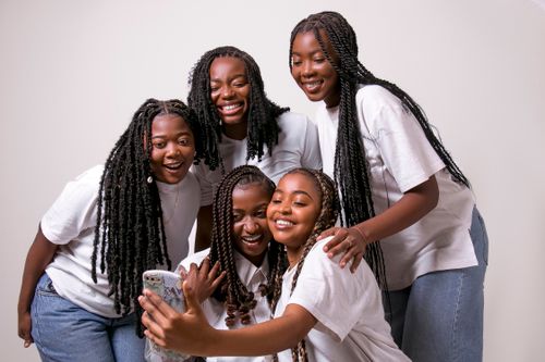 Free Five smiling African American women taking a selfie together indoors, exuding joy and togetherness. Stock Photo