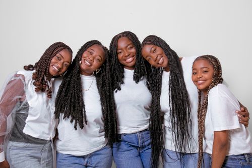 Free A cheerful group of five young black women happily posing together in casual outfits. Stock Photo