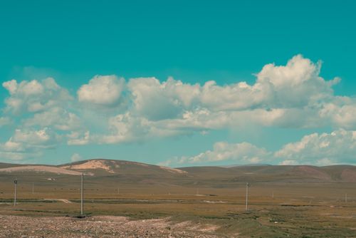 Free Expansive view of Altay region with rolling hills and clouds in Xinjiang, China. Stock Photo