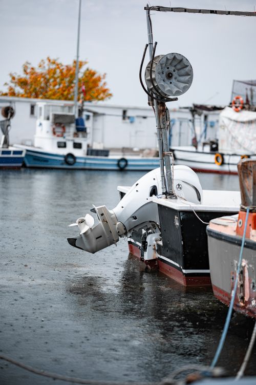 Free Fishing boats docked at Yalova harbor in rainy weather, showcasing maritime industry. Stock Photo