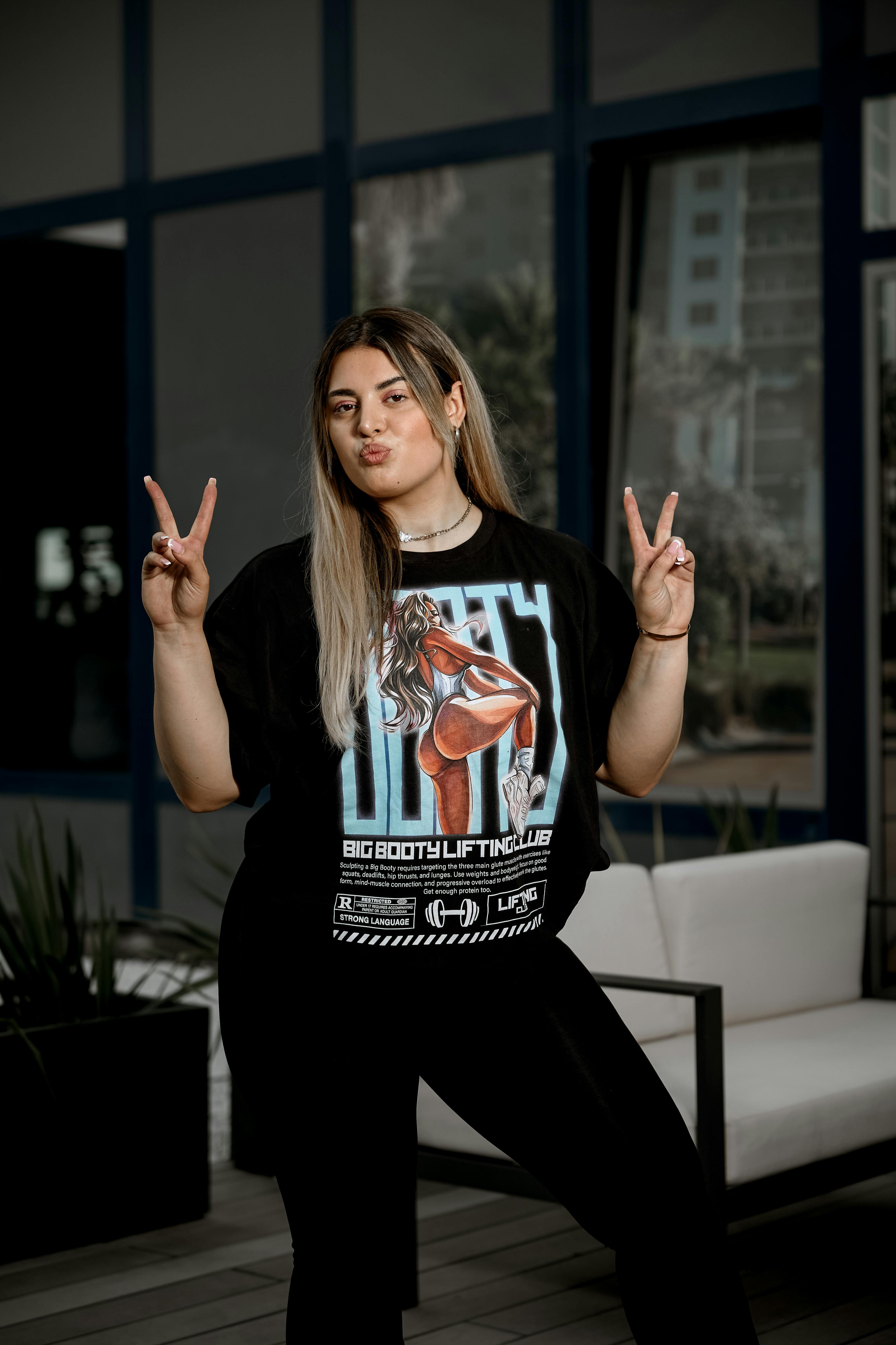 a woman in a black shirt making the peace sign