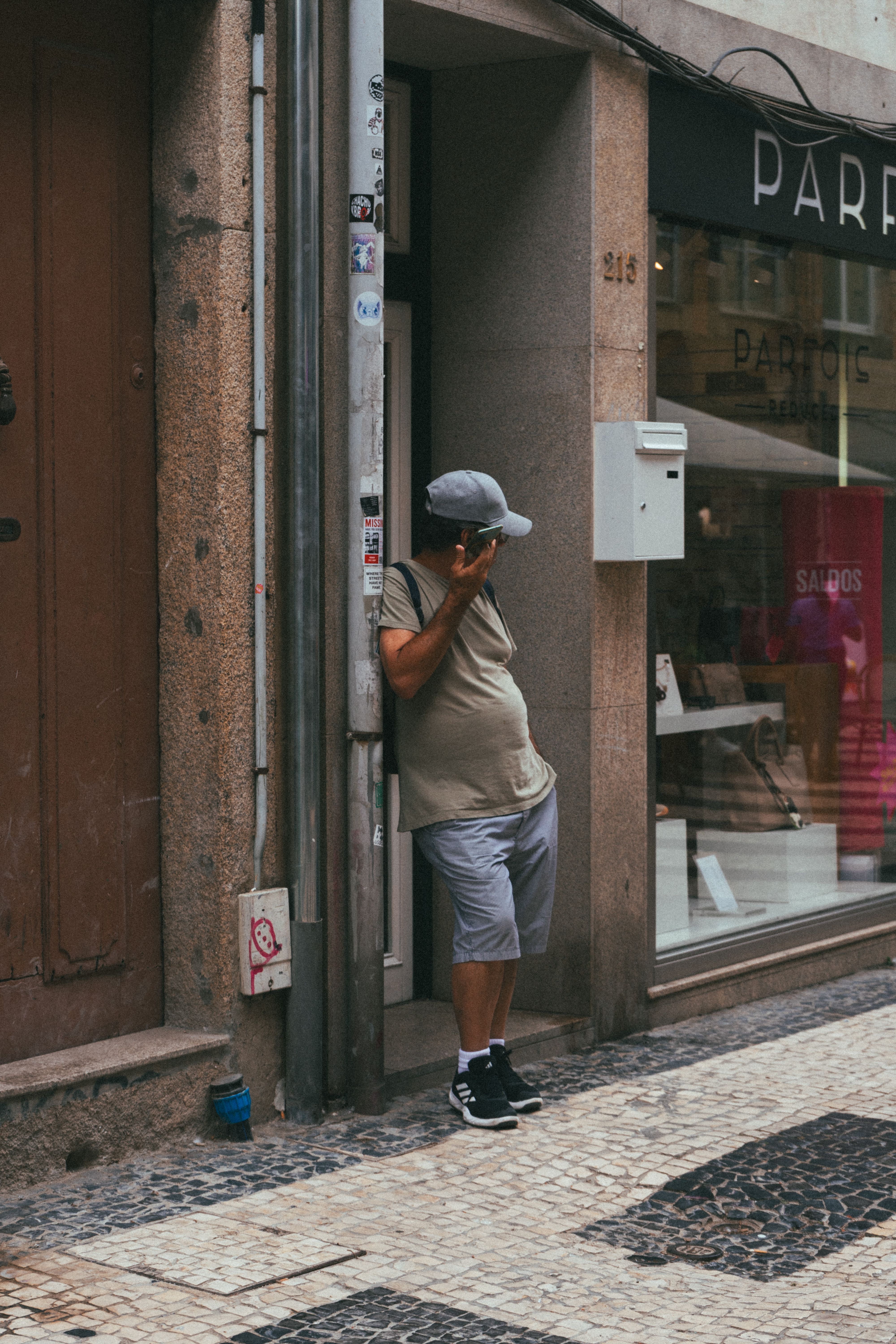 Local shop storefront with a customer checking a phone map outside